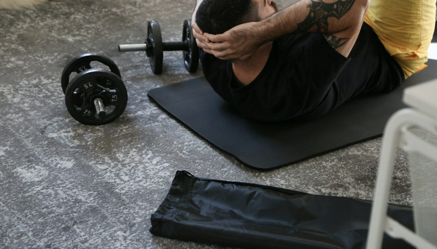 a man is doing exercises on a mat with a barbell