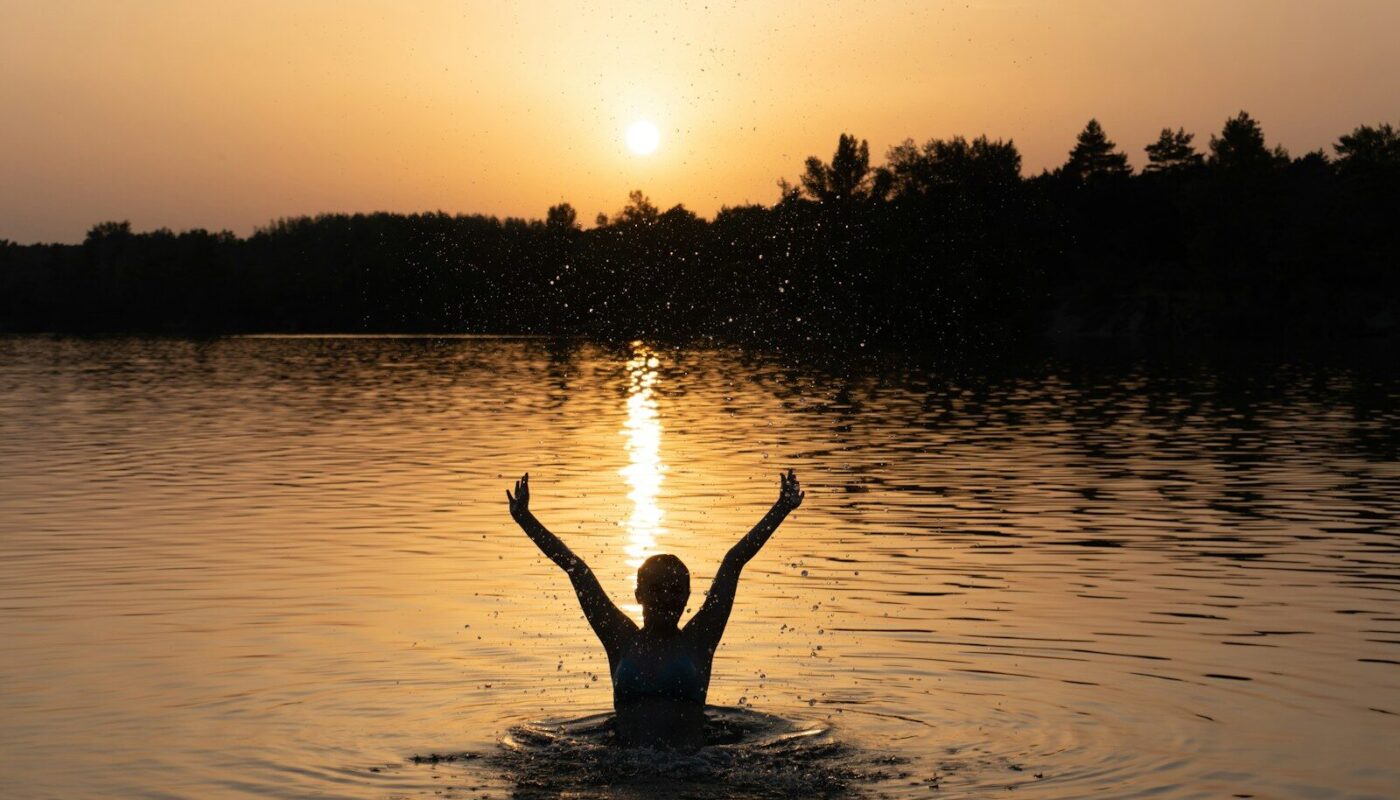a person in a body of water with their arms in the air