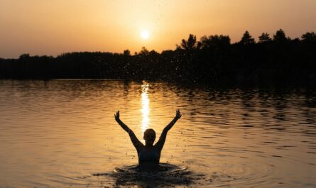 a person in a body of water with their arms in the air