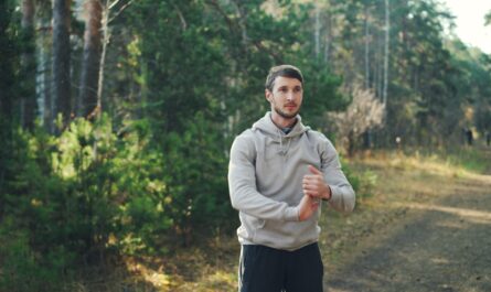 Man stretching outdoors in a forest setting.
