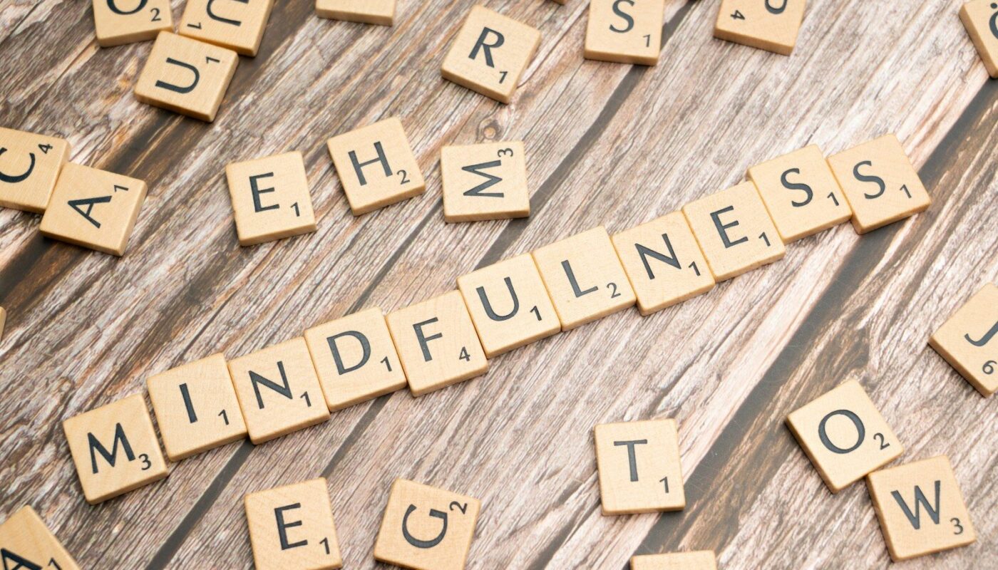 scrabble tiles spelling the word mindfulness on a wooden surface