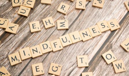 scrabble tiles spelling the word mindfulness on a wooden surface